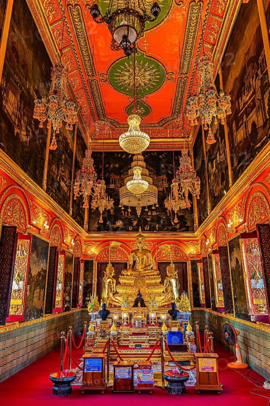 Beautifully furnished temple room with golden Buddha statue, sparkling chandeliers and pond-decorated wall and ceiling elements, Wat Paramai Yikawat Buddhist temple complex, Koh Kret river island, Bangkok, Thailand