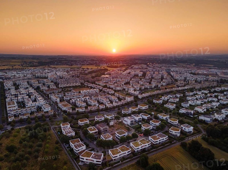 The sun rises behind the houses in Frankfurt's Riedberg district, Germany