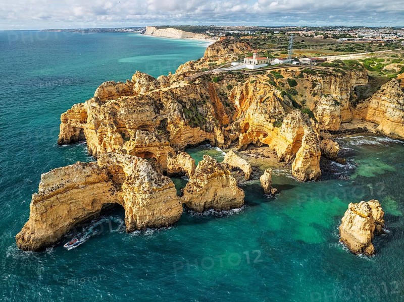 Drone view of Ponte da Piedade in Lagos, Algarve, Portugal, with sea stacks, cliff shadows and Atlantic ocean water