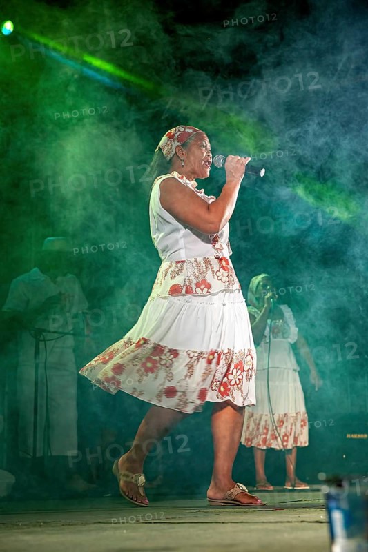 Moving singer on stage with microphone, dynamic fog and light play, a band plays and dances at a festival in Petrolina in Brazil