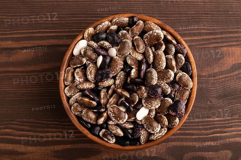 Wooden bowl with Kidney beans on brown wooden background, top view, flat lay, close up, minimalism