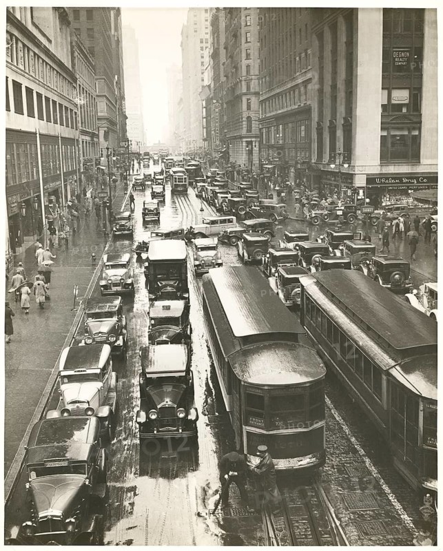 New York, 42nd Street, rain, traffic, streetcars, shops, department stores, Manhattan, USA, people and vehicles fill a rain-soaked street in the midst of an urban backdrop, around 1935