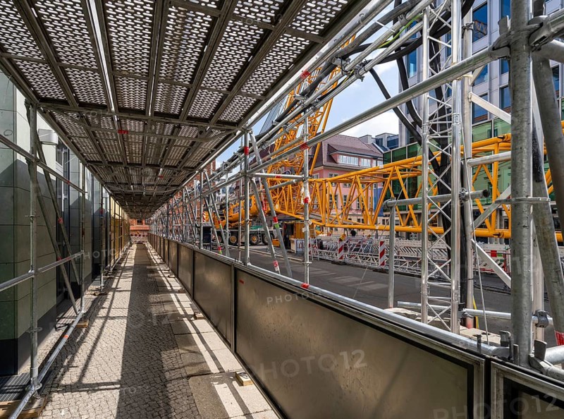 Scaffolding with steel boards, Mobi Hub, heavy construction machine with special technology setting up a crane in the narrow Schumannstraße at Agries Sorma Park, Berlin, Germany