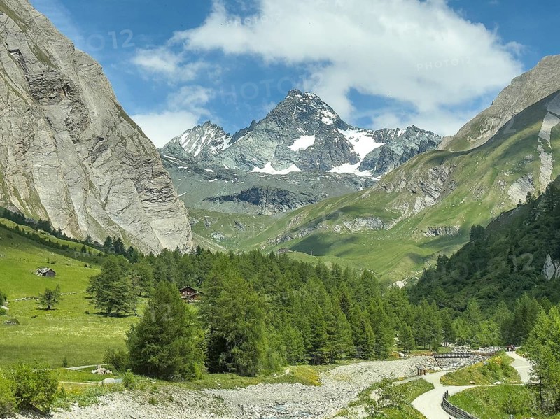 View from Ködnitztal on the south side of Grossglockner, larch forest in the Ködnitz Valley in the foreground, small bridge for hiking trail across Ködnitzbach, Tyrol, Austria