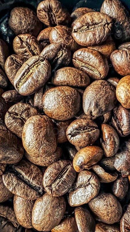 Stacking coffee beans with visible texture and warm tint, coffee beans