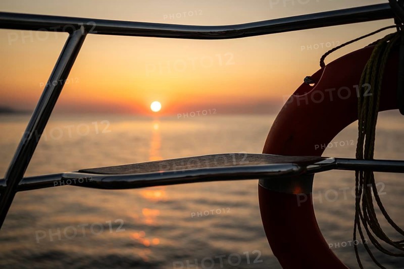 View of Mediterranean Sea and setting sun from a sailing ship through lifebuoy, Strait of Messina, Calabria, Aeolian or Aeolian Islands, Sicily, Southern Italy, Italy