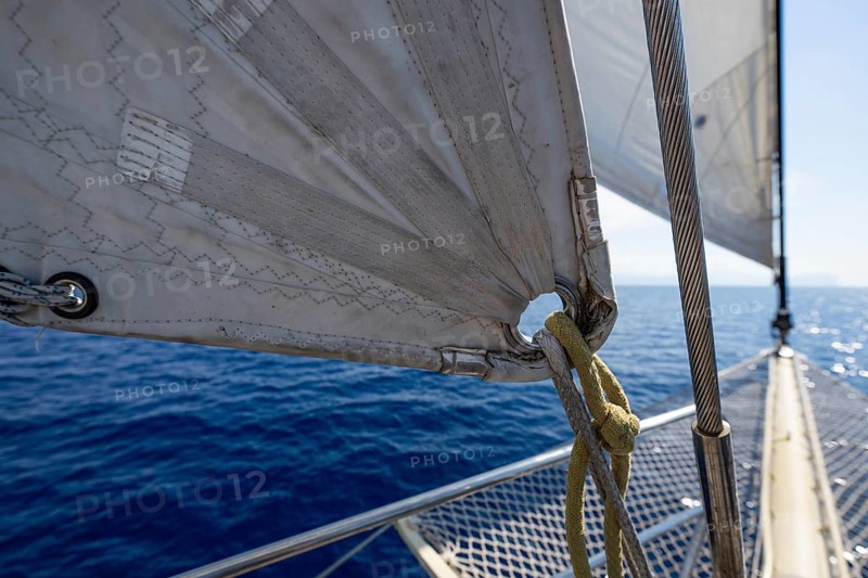 Close-up of a sail and dew with a view of calm, blue sea, Aeolian or Lipari islands, Sicily, southern Italy, Italy