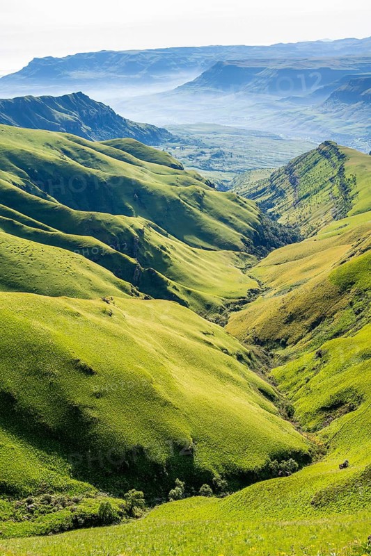 Green meadows and mountain valley, cathedral range mountain landscape, Drakensberg Mountains, KwaZulu-Natal, South Africa