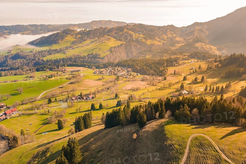 A wide landscape view with villages, forests and mountains in sunlight, Allgäu, Bavaria, Germany