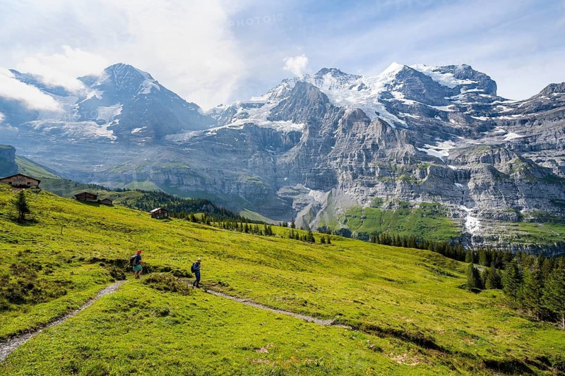 Two hikers on a hiking trail on Mettlenalp, mountain panorama with peaks Eiger, Mönch and Jungfrau, Bernese Alps, Bernese Oberland, Switzerland