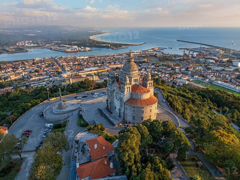 Drone shot of the famous Sanctuary of Santa Luzia at dusk with the city lights starting and ocean in Viana do Castelo, Portugal