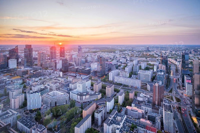 High viewpoint over the Warsaw skyline in Poland with skyscrapers, cityscape layers, city depth, sunset color and dramatic sky