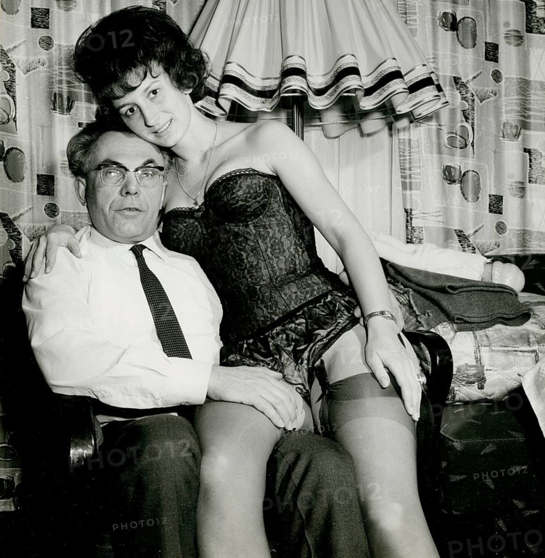 A man is sitting whilst a woman in lingerie sits provocatively on his lap, Herbert Jacobi (1915–1978), Self-Portrait, 1966