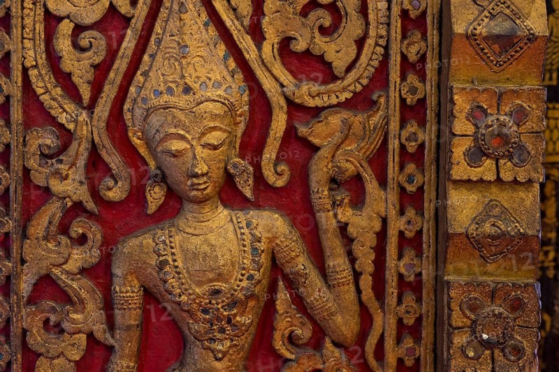 Carved wooden figure of an apsara dancer in the Buddhist Wat Xieng Tong or Vat Xienthong, Thong, Luang Prabang, Luang Prabang Province, Laos