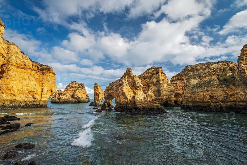 Surf, rocks and sea stacks create an ocean scene at Ponte da Piedade in Lagos, Algarve, Portugal, below cliffs
