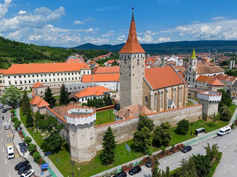Aerial view of medieval castle with red tile roofs and towers surrounded by green landscape and blue sky, aerial view, citadel, Aiud, Strasbourg-on-Mieresch, Alba County, Transylvania region, Romania