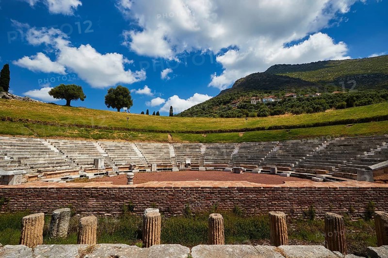 Ancient amphitheatre with green hills and blue sky in the background, Messene Theatre, Ancient Site, Archaeological Site, Messene, Messini, Messinia, Southwest of the Peloponnese, Odyssey, Odysseus, Ulysses, Movie, Filming Location, Matt Damon, Peloponnese, Peninsula, Greece