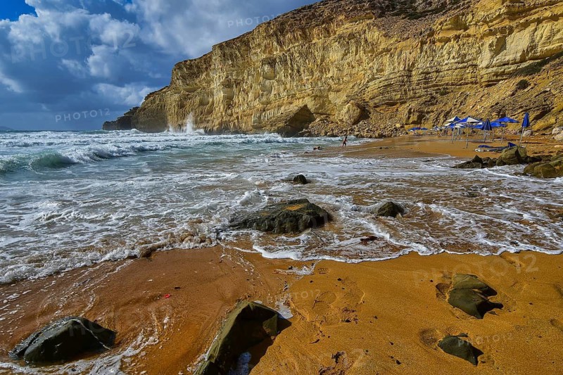 Red Beach, dream beach in the neighboring bay of Matala, rocky coast with waves, lonely swimmers and blue sky with clouds, Matala, south coast, Crete, Greek Islands, Greece