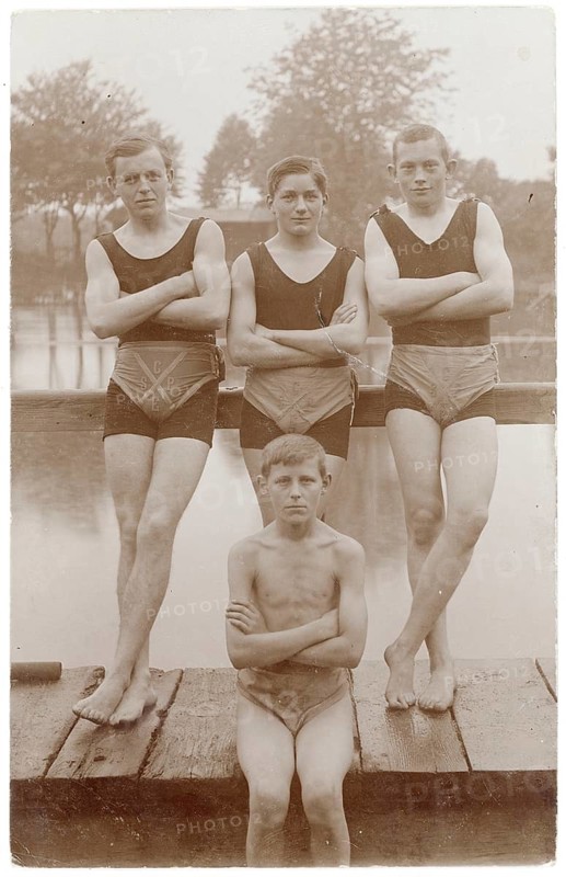 Bathing, swimwear, leisure, summer, swimming club, lake, outdoor pool, four boys in bathing suits standing and sitting on a wooden walkway by the river. Quiet atmosphere, around 1925