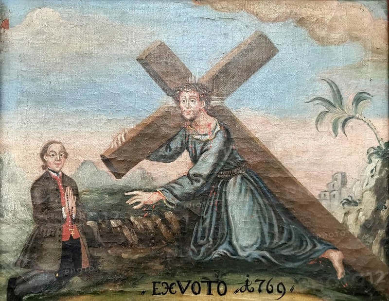 Votive image from the 18th century in the monastery church, Mönchsdeggingen monastery, former monastery of the Mariannhill missionaries, near Nördlingen on the southern edge of Riesrand, Donau-Ries district, Swabia, Bavaria, Germany. The picture shows Jesus Christ under the cross, as he is depicted in traditional iconography of carrying the cross or collapsing on the Way of the Cross. On the left side, the founder of the painting kneels in contemporary clothing from the late 18th century. He holds a rosary in his hands while praying