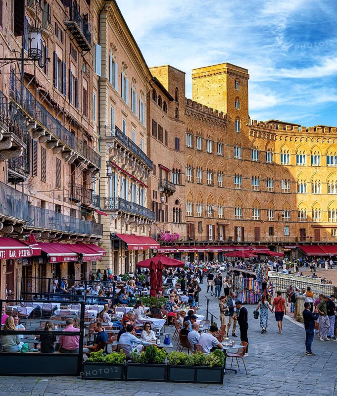 Tourists, sights and restaurants on the famous Piazza del Campo, Siena, Tuscany, Italy