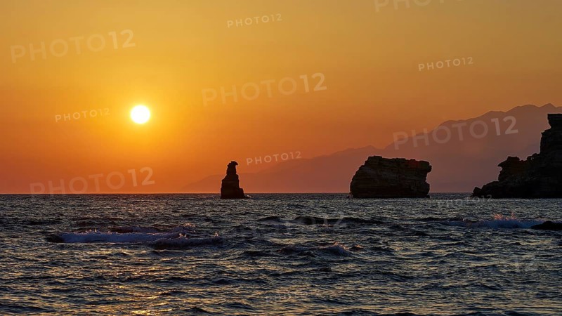 Rocks and the sea in front of an intense orange sunset with a clear sky, sunset, south of the Amari Basin, Central Crete, Triopetra, rocks in the sea, Crete, Greek Islands, Greece