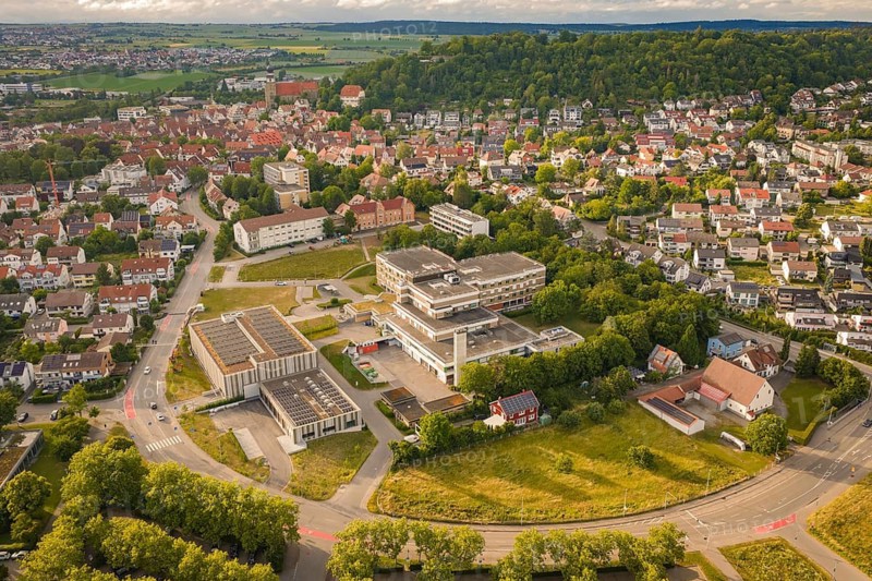 Aerial view of a green urban landscape with residential buildings and roads surrounded by hills under cloudy sky, new IGZ, Herrenberg Integrated Health Center, former Herrenberg Hospital, Böblingen district, Germany