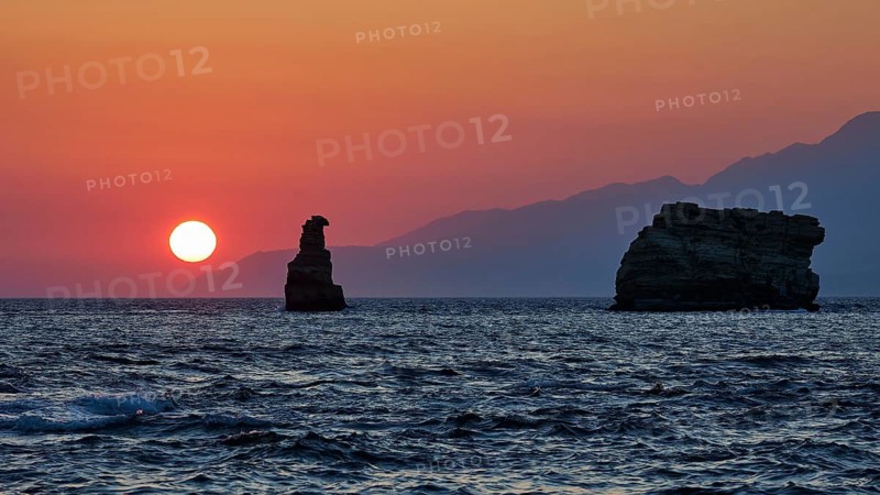 Red sunset over the sea with rocks in the foreground and mountains in the background, sunset, South of the Amari Basin, Central Crete, Triopetra, rocks in the sea, Crete, Greek Islands, Greece