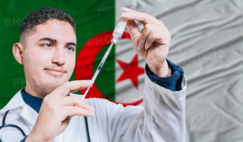 Doctor holding syringe on Algeria flag background. Medical professional holding syringe with Algerian flag in the background