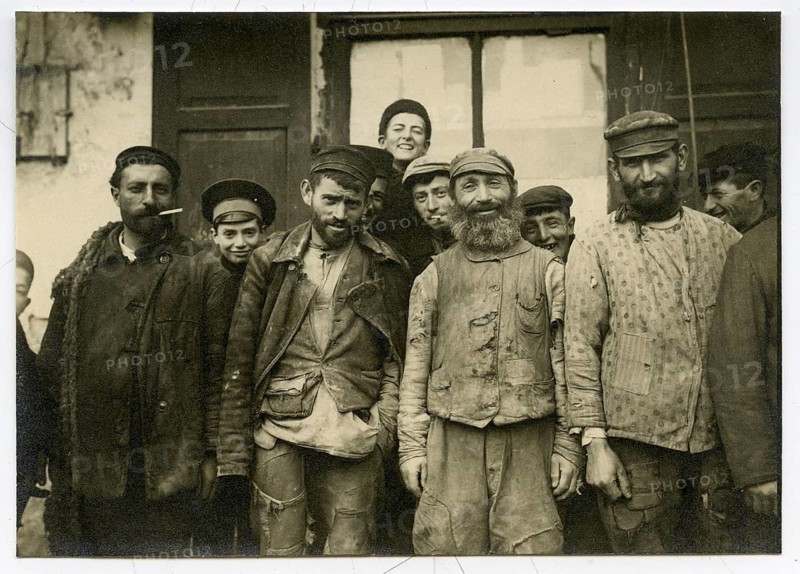 Jews, young men, traders, craftsmen, shtetl, Eastern Poland, Galicia, a group of men, some smiling, standing together in historic work clothes, atmosphere is comradely, around 1916