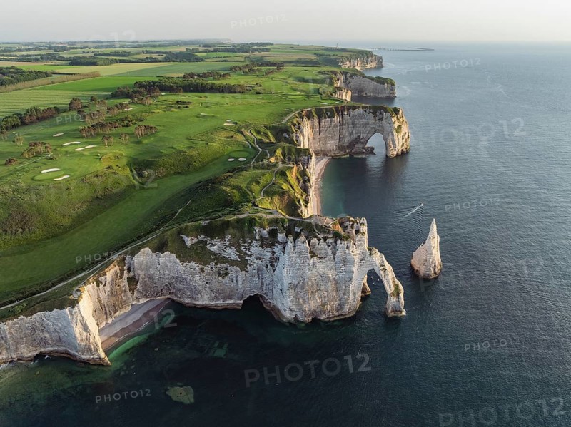 Aerial view of the Porte d'Aval rock formation in the evening sun, well-known sights on the chalk coast with the distinctive rock pin, behind it the La Manneporte rock formation and the Pointe de la Courtine ledge, then Pointe du Fourquet, right on the cliffs the Golf d'Ètretat golf course founded in 1908, Alabaster Coast, La Côte d'Albâtre, chalk cliffs, English Channel, Seine-Maritime, Normandie, France