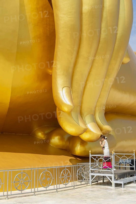 Thailand's largest Buddha statue (Luang Pho Yai), Thai woman, Wai gesture (traditional gesture of respect, greeting or thanks), Wat Muang, Ang Thong, Amphoe Wiset Chai Chan province, Thailand