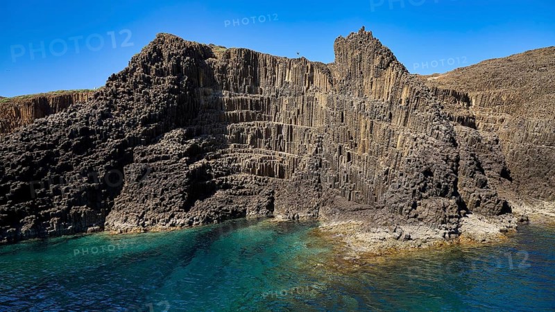 An impressive cliff landscape with distinctive basalt columns and blue sea, Glaronisia, Glaronesia, Milos, islets, hexagonal basalt columns, north of Milos, destination by boat, Cyclades, Greek Islands, Greece