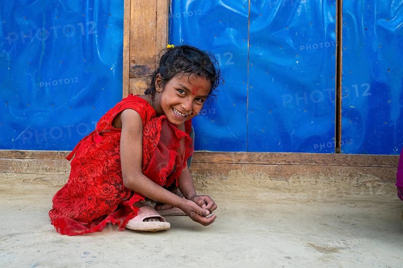 A little smiling girl playing with stones, Hindu ethnic group, Himalayas, Humla region, western Nepal, Nepal