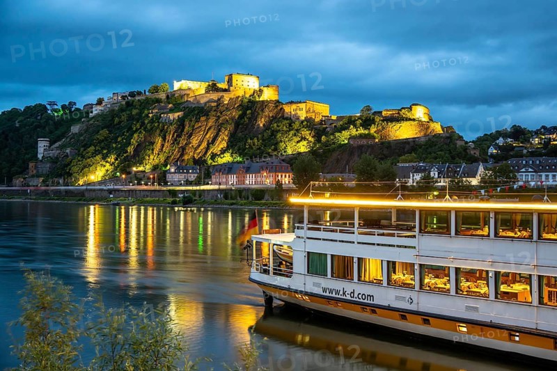 The Ehrenbreitstein Fortress, on the right side of the Rhine, opposite the Deutsches Eck, evening lighting, sightseeing boat on the left bank, Koblenz, Rhineland-Palatinate, Germany