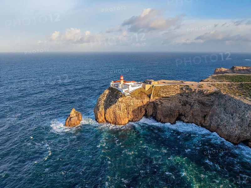 Drone view of the Lighthouse of Cabo de Sao Vicente in Sagres, Algarve, Portugal, at sunrise with Atlantic ocean, cliffs, and aerial Atlantic cliffs