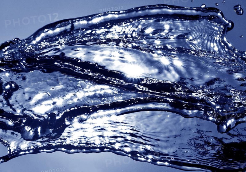 Water frozen by short exposure moving in backlight in front of the sun, duplex toning in blue
