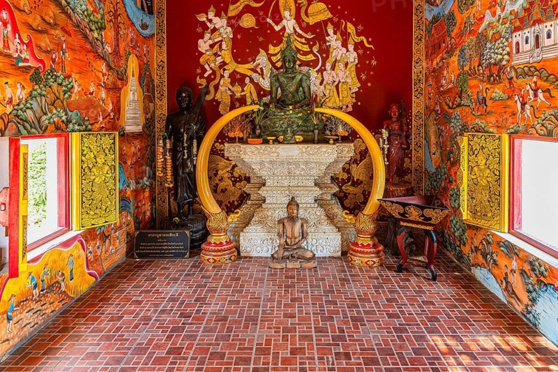 Small prayer room with various Buddha figures framed with elephant tusks, Buddhist temple complex Wat Chiang Yuen, Chiang Mai, Thailand