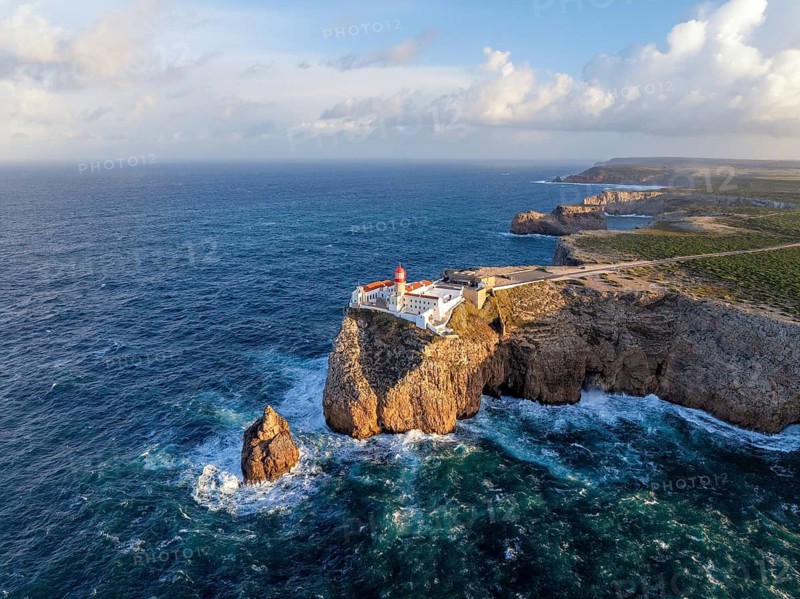 Drone view of the Lighthouse of Cabo de Sao Vicente in Sagres, Algarve, Portugal, at sunrise with Atlantic ocean, cliffs, and wide drone coastline