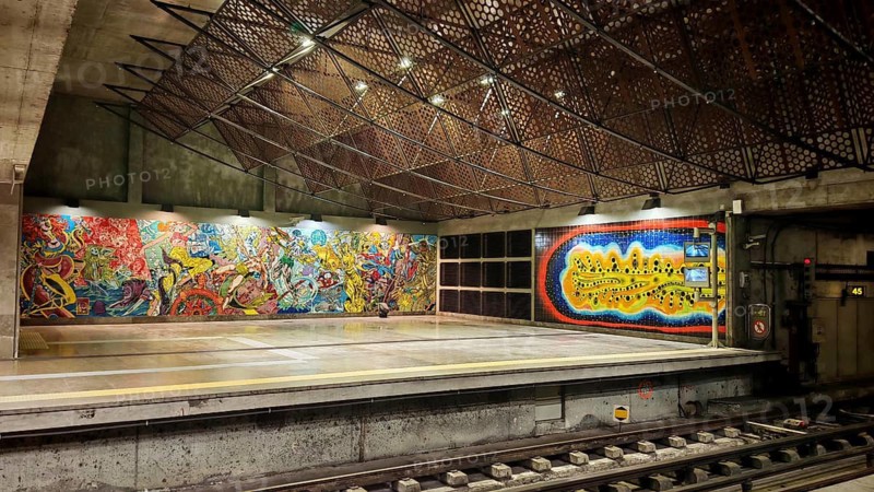 Colourful wall art in a modern subway station, with graffiti and illuminated grids on the ceiling, Lisbon, Portugal