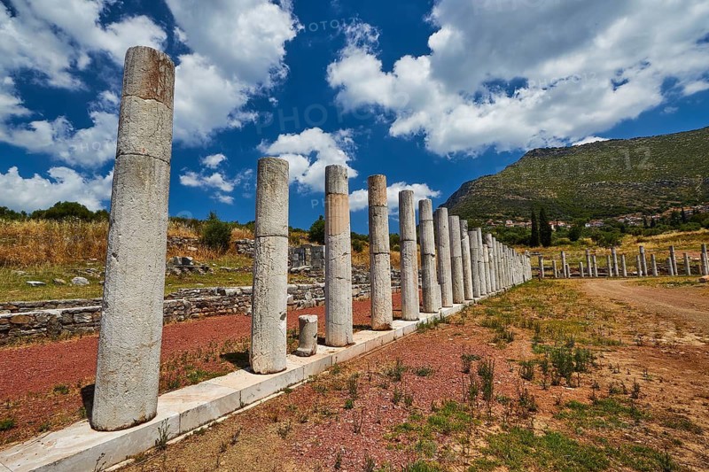 Historic column ruins lead in front of a mountain under a blue sky, Messene Stadium, Ancient Site, Archaeological Site, Messene, Messini, Messinia, Southwest of the Peloponnese, Odyssey, Odysseus, Ulysses, Film, Filming Location, Matt Damon, Peloponnese, Peninsula, Greece