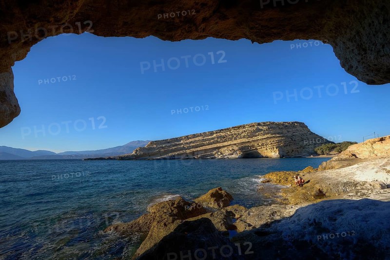 Neolithic caves, former hippie paradise, view from a cave of the deep blue sea and a rocky coast on a sunny day, Matala, south coast, Crete, Greek Islands, Greece