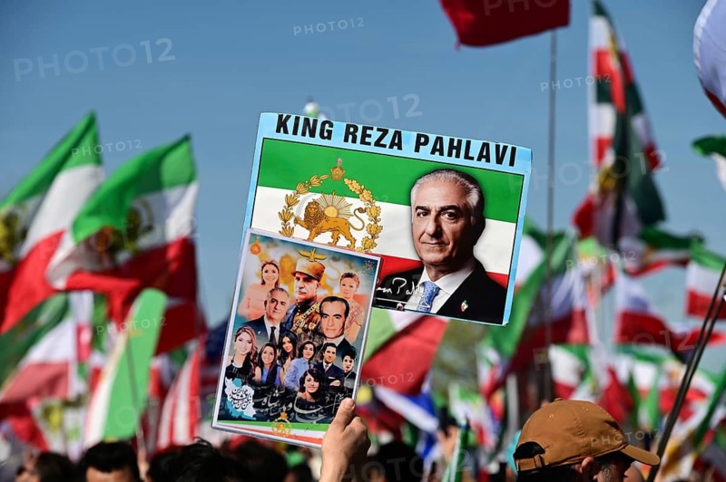 Supporters of Reza Pahlavi demonstrate in front of the Reichstag, including with numerous different flags and posters, which establish Pahlavi's connection to the Shah dynasty and his role as prince and potential future king