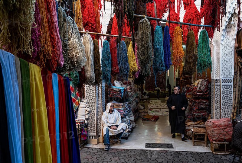 Dyed wool and colorful cloths are hung to dry over a carpet shop, quarter of wool dyers, souk, bazaar, Maghreb, Marrakech, Morocco