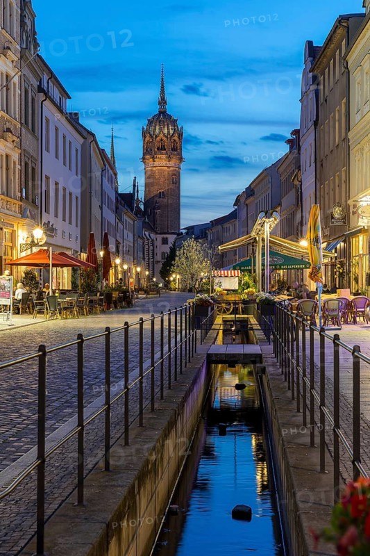 Schlossstraße in the evening with castle church tower and Röhrwasser, Luther city Wittenberg, Saxony-Anhalt, Germany