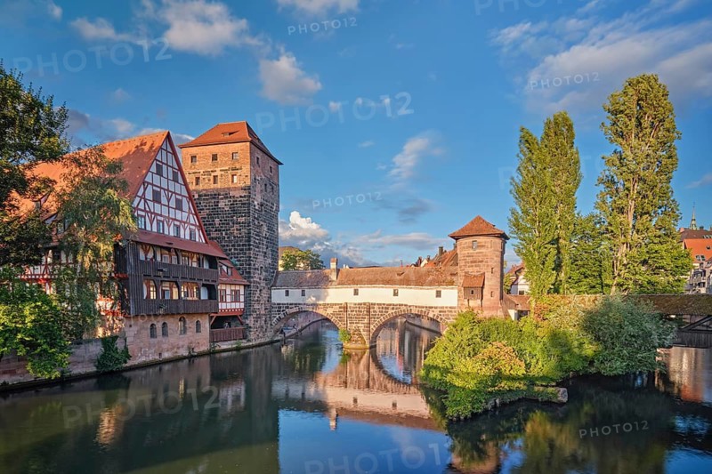 Beautiful reflections of the historic Henkersteg bridge and half-timbered houses in the Pegnitz river, Nuremberg, Germany