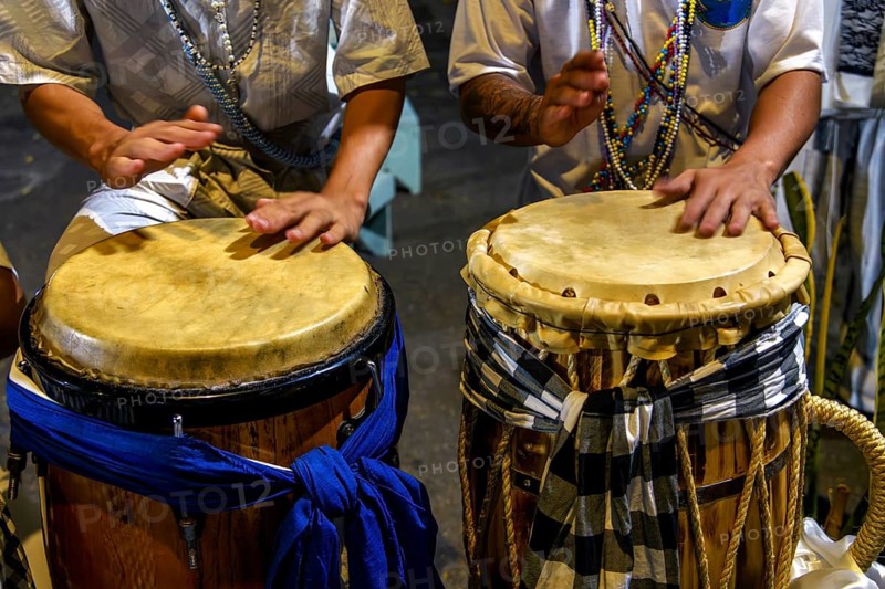 Drummers playing a traditional atabaque drum decorated with cloths during an Umbanda celebration in Brazil, Belo Horizonte, Minas Gerais, Brazil