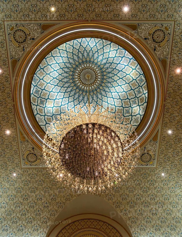 An upward view of a crystal chandelier hanging from the intricately decorated geometric dome, Qasr Al Watan Presidential Palace, Abu Dhabi, UAE