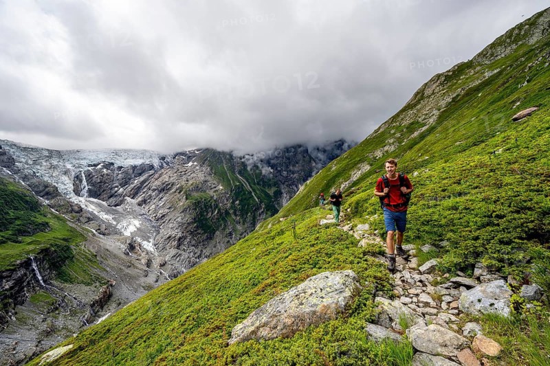Mountaineers on a hiking trail, cloudy mountain landscape with Grindelwald-Fiescherfirn glacier, Bernese Alps, Bernese Oberland, Switzerland