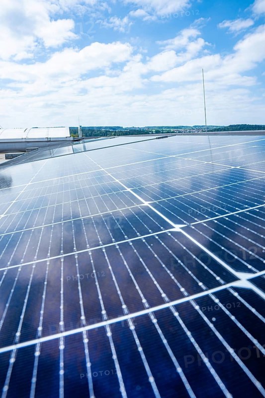 Solar modules on a roof against a blue, cloudy sky, PV installation, Perrot company, Calw, Germany